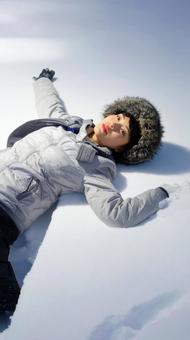 雪の上に寝そべる女性 雪の上に寝そべる女性の写真