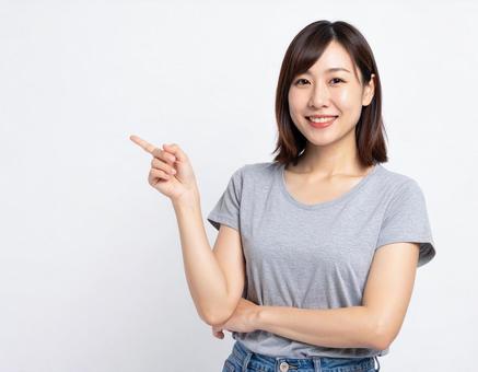 笑顔で指さす30代の日本人女性 笑顔で指さす30代の日本人女性の写真