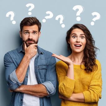 何かに首をかしげる若いカップル 何かに首をかしげる若いカップルの写真
