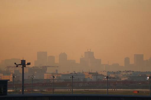 オレンジ色の空と空港と港湾とビル群の街 オレンジ色の空と空港と港湾とビル群の街の写真