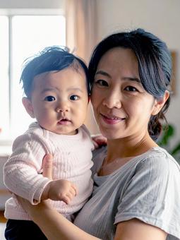 赤ちゃんを抱っこするお母さん 赤ちゃんを抱っこするお母さんの写真