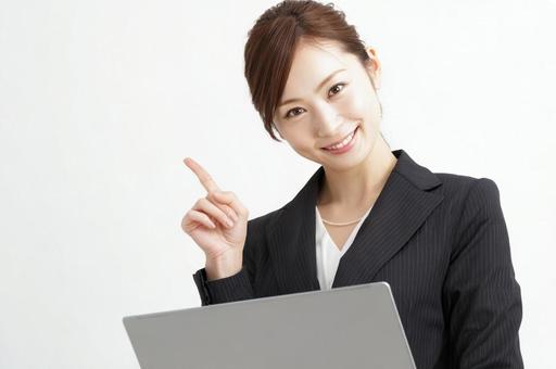 パソコンを持ち指をさす女性-2の写真