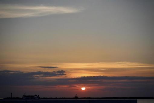 海に沈む夕日と船 海に沈む夕日と船の写真