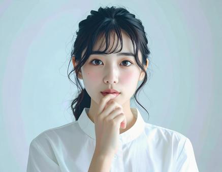 女性が口元に指を添えるポートレートの写真