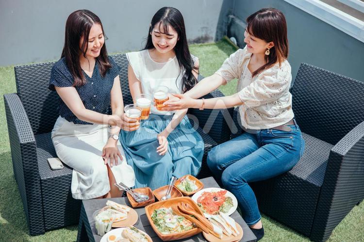 屋上でパーティーをする女性たち（ビール） ビアガーデン,パーティー,ホームパーティーの写真素材