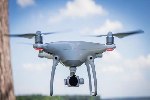 飛行している空撮ドローンのクローズアップ 飛行している空撮ドローンのクローズアップ ドローン,メカ,マルチコプターの写真素材