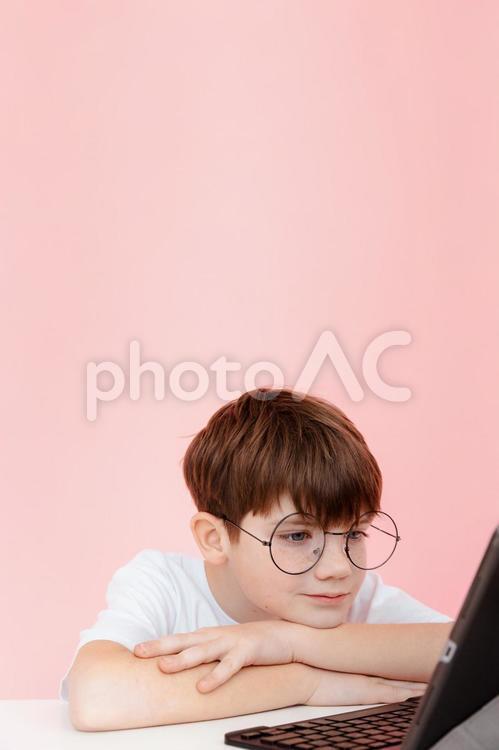 微笑みパソコンを見るメガネの男の子 男の子,ノートパソコン,見るの写真素材
