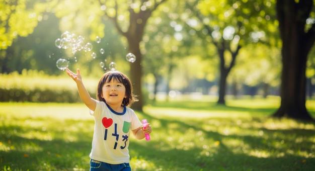 シャボン玉で遊ぶ笑顔の男の子 シャボン玉で遊ぶ笑顔の男の子の写真