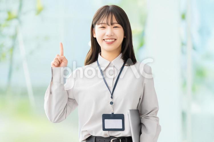 人差し指を立てて案内する笑顔の女性 女性,ビジネス,笑顔の写真素材
