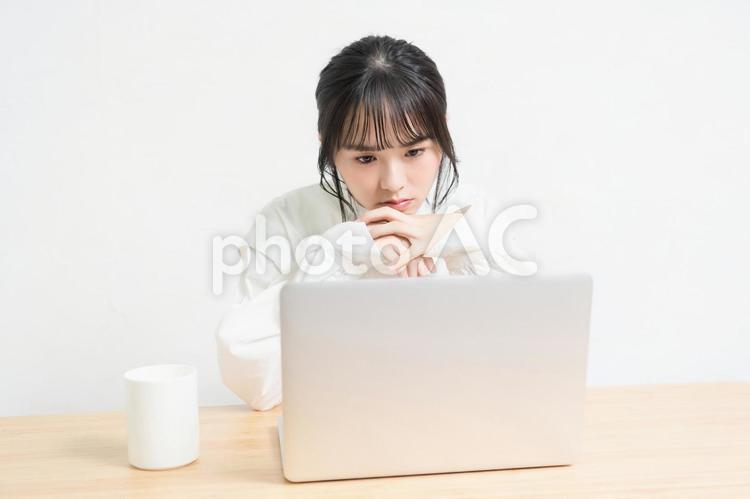 ノートパソコンを使いながら悩んでいる女性 ノートパソコン,パソコン,女性の写真素材