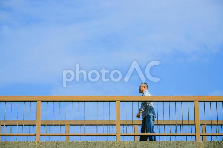 橋の上を歩くシニア男性 シニア,屋外,散歩の写真素材