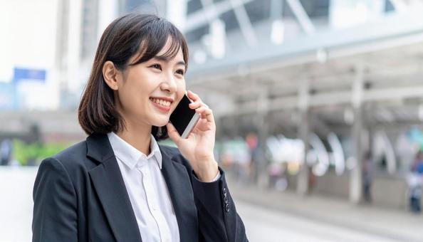スマホで通話する女性・ビジネスウーマン スマホで通話する女性・ビジネスウーマンの写真