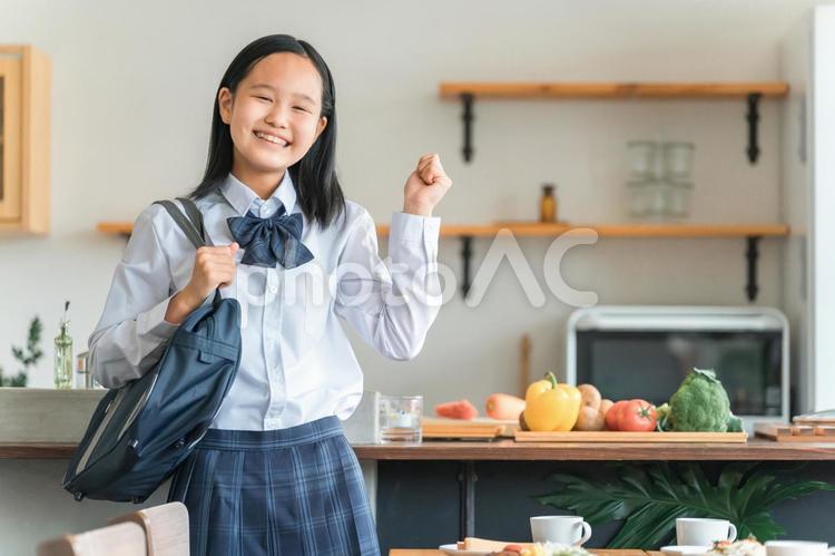 家のキッチンにいる制服を着た女子高校生 学生,高校生,笑顔の写真素材