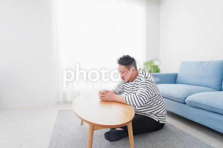 部屋でお茶を飲む中年男性 ソファ,見つめる,のんびりの写真素材