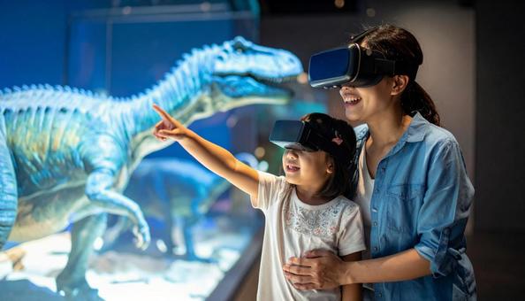 VRゴーグルで恐竜のホログラムを見る親子 VRゴーグルで恐竜のホログラムを見る親子の写真