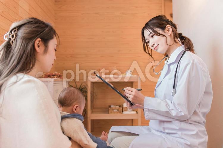 赤ちゃんを診察する産婦人科・女医とママ 医者,赤ちゃん,風邪の写真素材