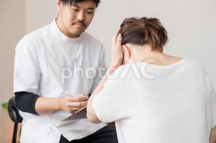 カウンセリングを受ける女性（発熱・頭痛） 整体,頭痛,熱の写真素材