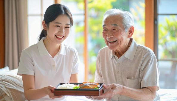 高齢男性と女性介護士の穏やかな食事風景 高齢男性と女性介護士の穏やかな食事風景の写真