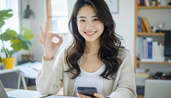 家計がうまくいきスマホ片手に微笑む女性の写真