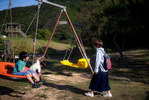 <素材>夏の公園でブランコで遊ぶ親子 <素材>夏の公園でブランコで遊ぶ親子 女性,子供,男性の写真素材