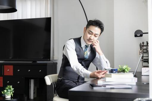 出勤前にスマートフォンを使う男性 出勤前にスマートフォンを使う男性 ビジネスマン,男性,人物の写真素材