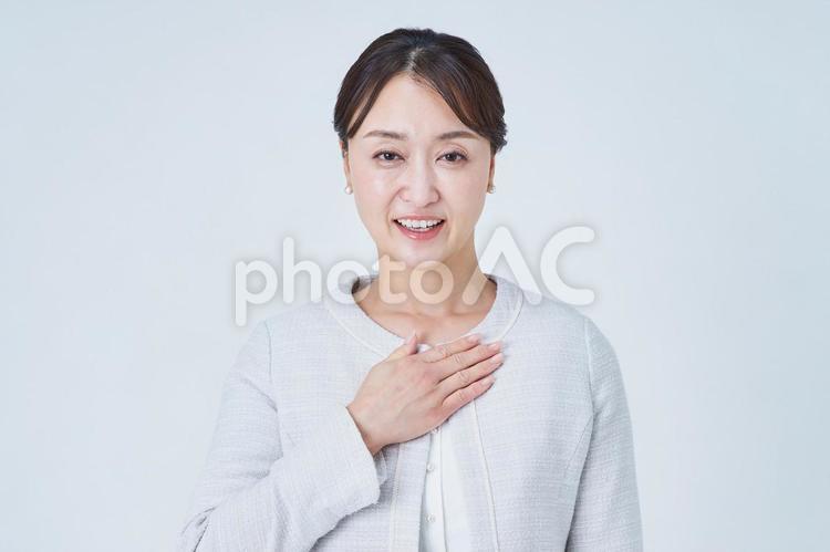 胸に手を当てるビジネスウーマン 胸に手を当てるビジネスウーマン 女性,応援,安心の写真素材