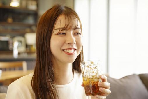 笑顔でアイスティーを飲む女性 笑顔でアイスティーを飲む女性 女性,若い,笑顔の写真素材