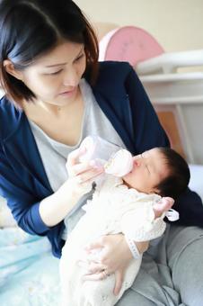 新生児の赤ちゃんにミルクをあげる母親 新生児の赤ちゃんにミルクをあげる母親 赤ちゃん,子供,乳児の写真素材