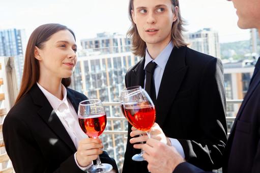 ワイングラスを持ち話を聞いている男女 男女,外国人,ビジネスの写真素材