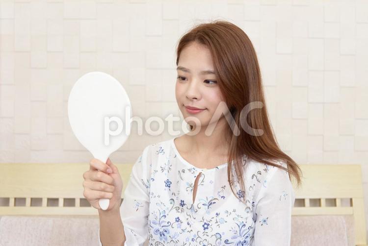 手鏡を持って肌の状態を確かめる女性 女性,美容,スキンケアの写真素材