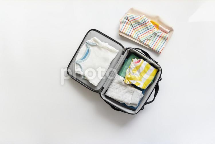 カラフルなストライプの洋服と旅行バッグの中に 旅行バッグ,緑,ぬいぐるみの写真素材