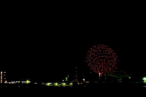 工場夜景と花火の写真