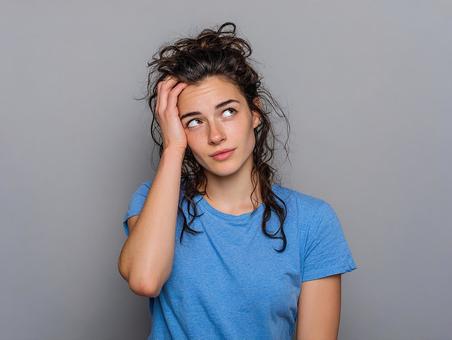 不安を感じる若い女性:手で顔を覆うポーズ 不安を感じる若い女性:手で顔を覆うポーズの写真