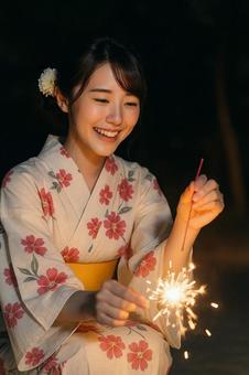 花火を楽しむ浴衣姿の女性 花火を楽しむ浴衣姿の女性の写真