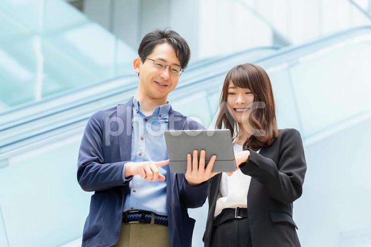 タブレットを見ながら話す男女ビジネスマン 男性,女性,男女の写真素材