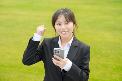 スマホを持ってガッツポーズをする女性 スマホを持ってガッツポーズをする女性 日本人,女性,20代の写真素材