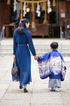 母親と手をつないで歩く男の子 母親と手をつないで歩く男の子の写真