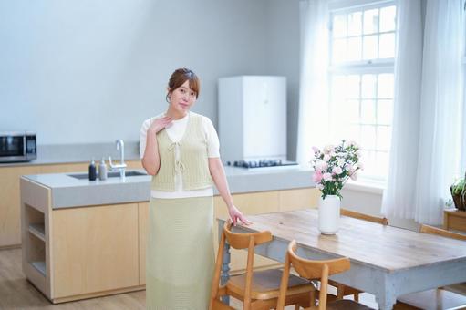 カメラ目線の女性と机の上の花の写真