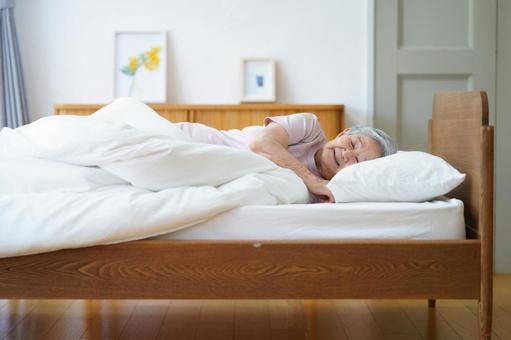 ベッドで眠る半袖の女性 女性,寝る,目を瞑るの写真素材