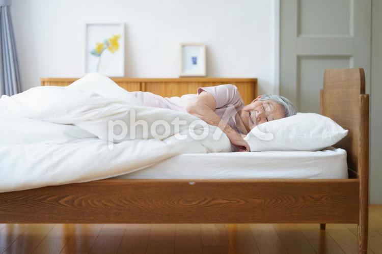 ベッドで眠る半袖の女性 女性,寝る,目を瞑るの写真素材