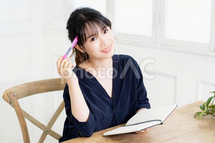 ノートとペンを持つ若い女性 女性,ビジネス,ノートの写真素材