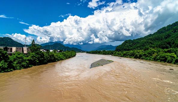 台風の後、増水して濁った川と青空 台風の後、増水して濁った川と青空の写真