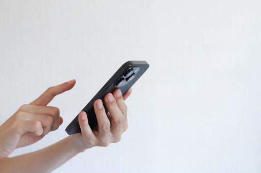スマートフォンを使う手元 スマートフォンを使う手元の写真