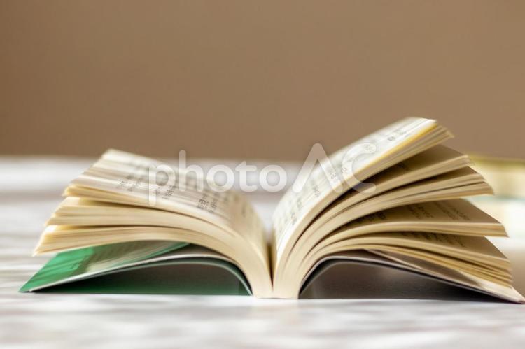 窓際の机の上に開かれた本 本,読書,机の写真素材