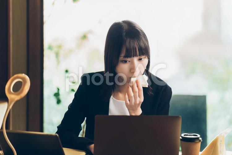 サンドイッチを食べながら仕事をする女性 女性,ビジネス,パソコンの写真素材