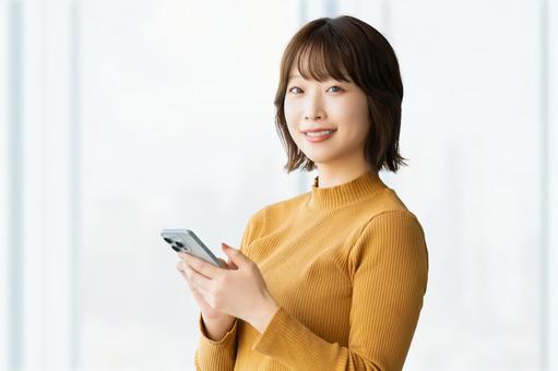 スマホを持つ笑顔の女性・ビジネスウーマン スマホを持つ笑顔の女性・ビジネスウーマン 女性,スマホ,笑顔の写真素材
