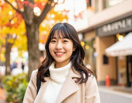 秋の街を歩く笑顔の女性 秋の街を歩く笑顔の女性の写真