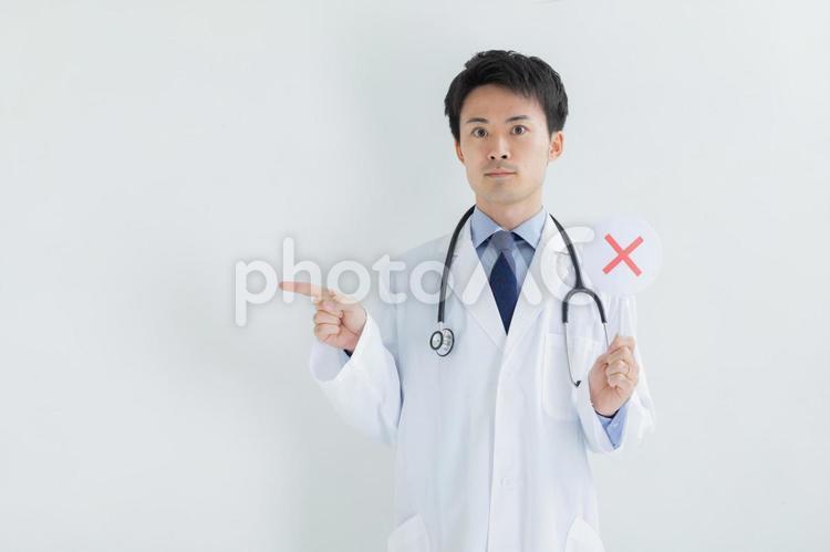 バツのプレートを持った医師　Doctor 医者,医師,白背景の写真素材