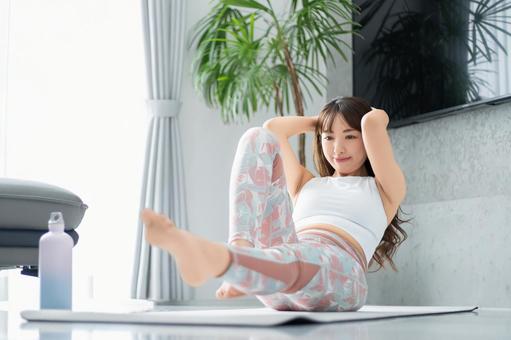 リビングでトレーニングをする女性 リビングでトレーニングをする女性 女性,運動,美容の写真素材