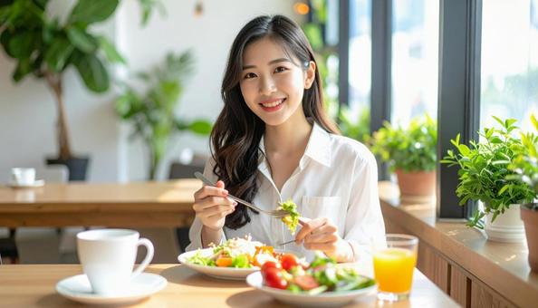 カフェでランチを楽しむ笑顔の日本人女性 カフェでランチを楽しむ笑顔の日本人女性の写真